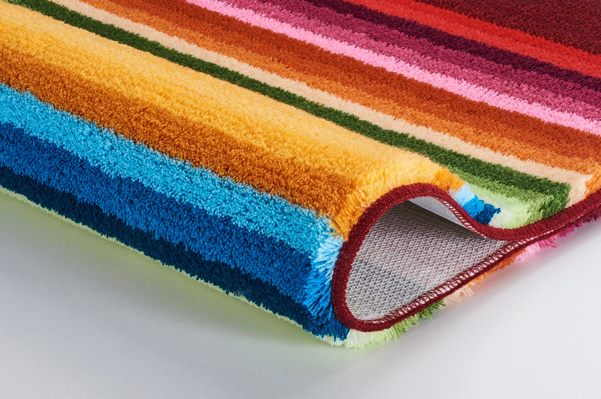 Bunter Badteppich mit dickem Flor und farbigen Streifen in Nahaufnahme