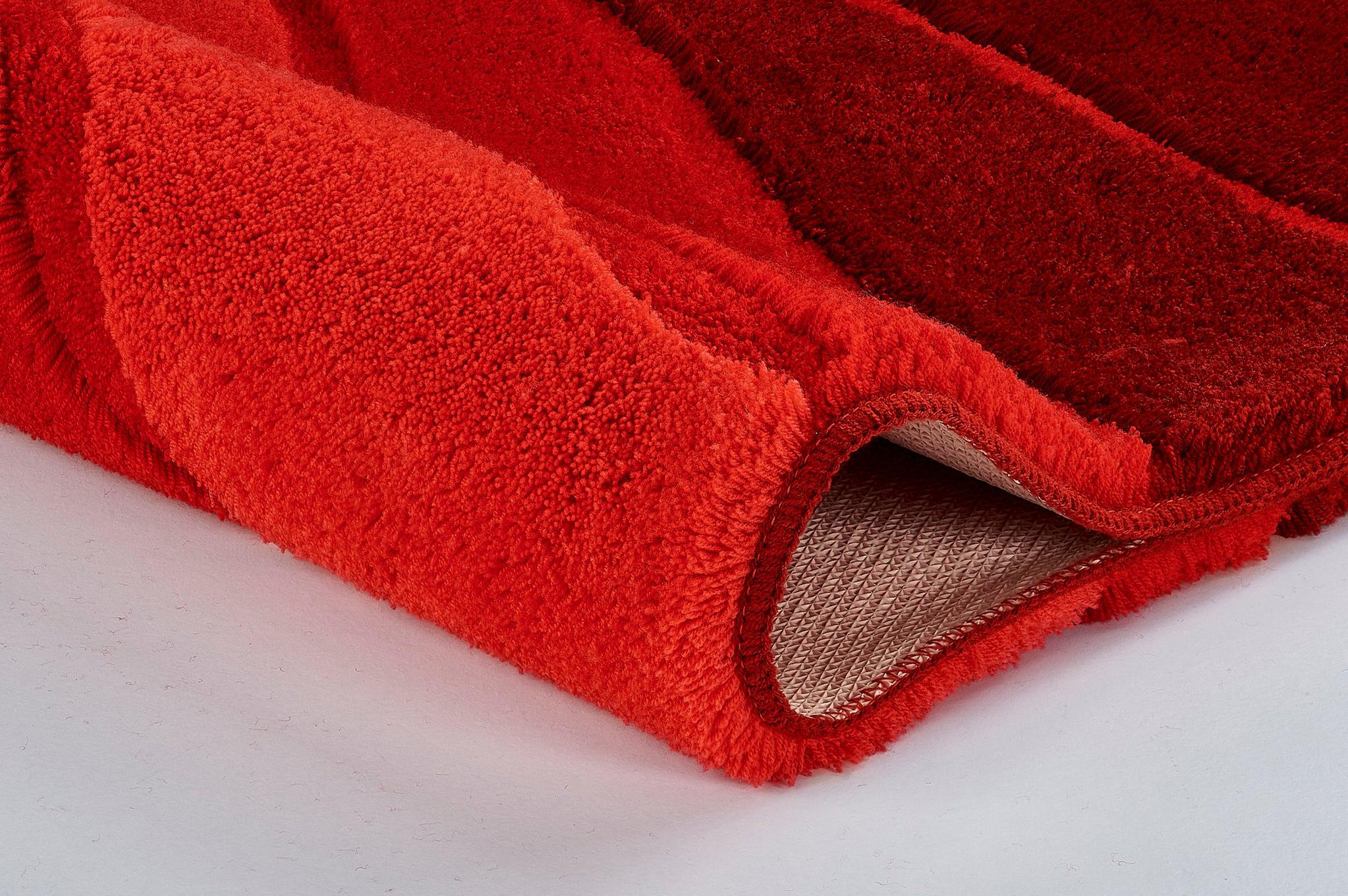 Nahaufnahme einer zweifarbigen roten Badematte mit weichem Hochflor