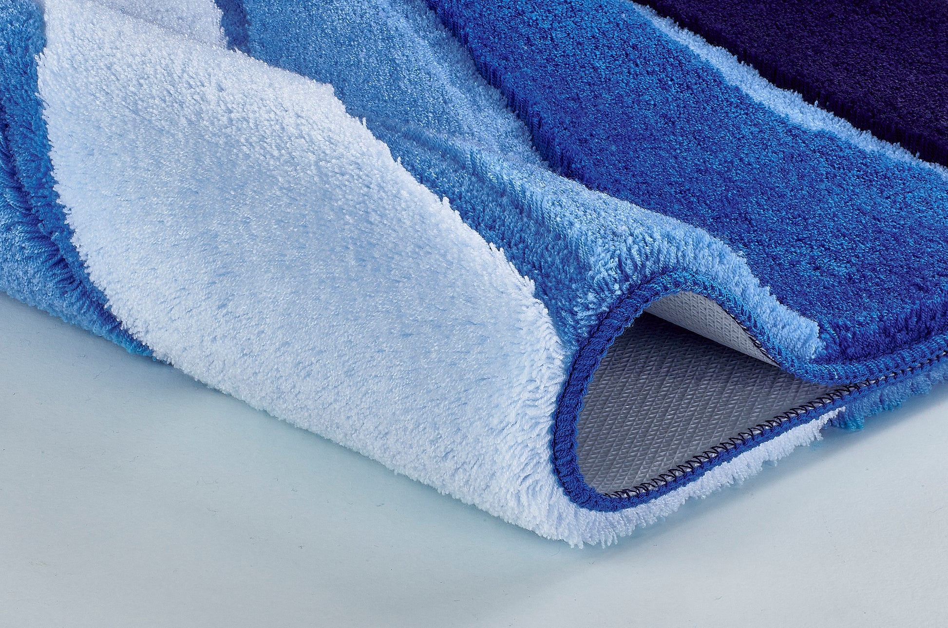 Nahaufnahme einer blau-weißen Badematte mit rutschfester Unterseite