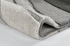 Nahaufnahme einer gefalteten, grau gestreiften Badematte aus Frottier