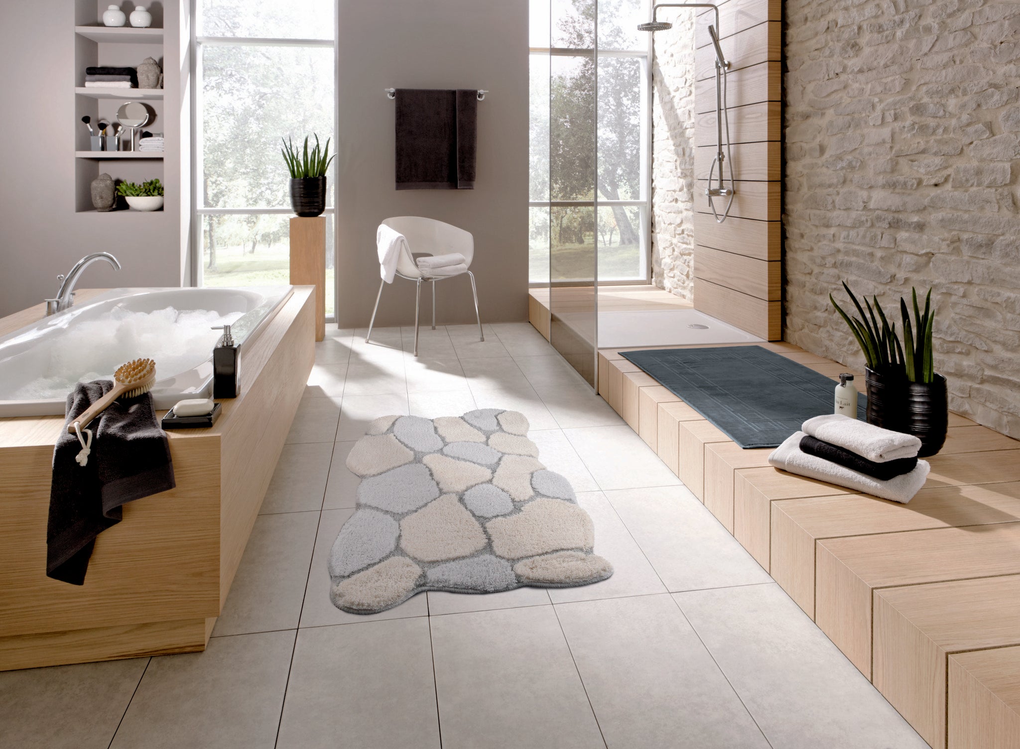 Modernes Bad mit Steinoptik-Badteppich, Wanne, Dusche und Handtüchern