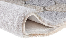 Der flauschige Teppich in Creme und Grau zeigt seine weiche Hochflorstruktur.
