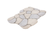 Ein flauschiger Badteppich in Beige und Grau mit Wabenmuster.