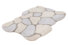 Der flauschige Teppich zeigt ein Steinmuster in Beige und Grau.