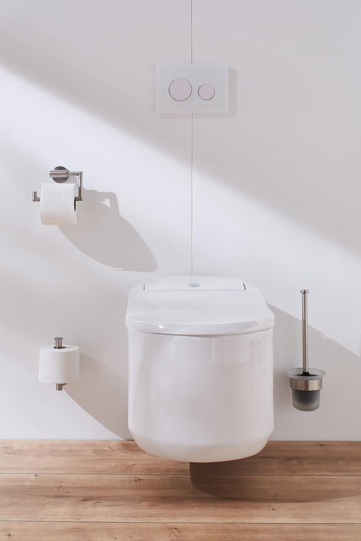 Wandhängendes weißes WC mit Spülkasten, Rollenhalter und Bürste aus Chrom