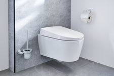Wandhängendes WC in Weiß mit Toilettenbürste und Papierhalter daneben