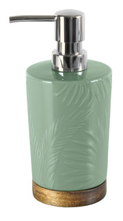 Seifenspender PALM Maledivia aus grünem Keramik mit Palmrelief und Holzfuß steht freigestellt.