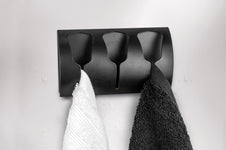 Schwarzer Wandhandtuchhalter mit zwei Handtüchern in Weiß und Schwarz
