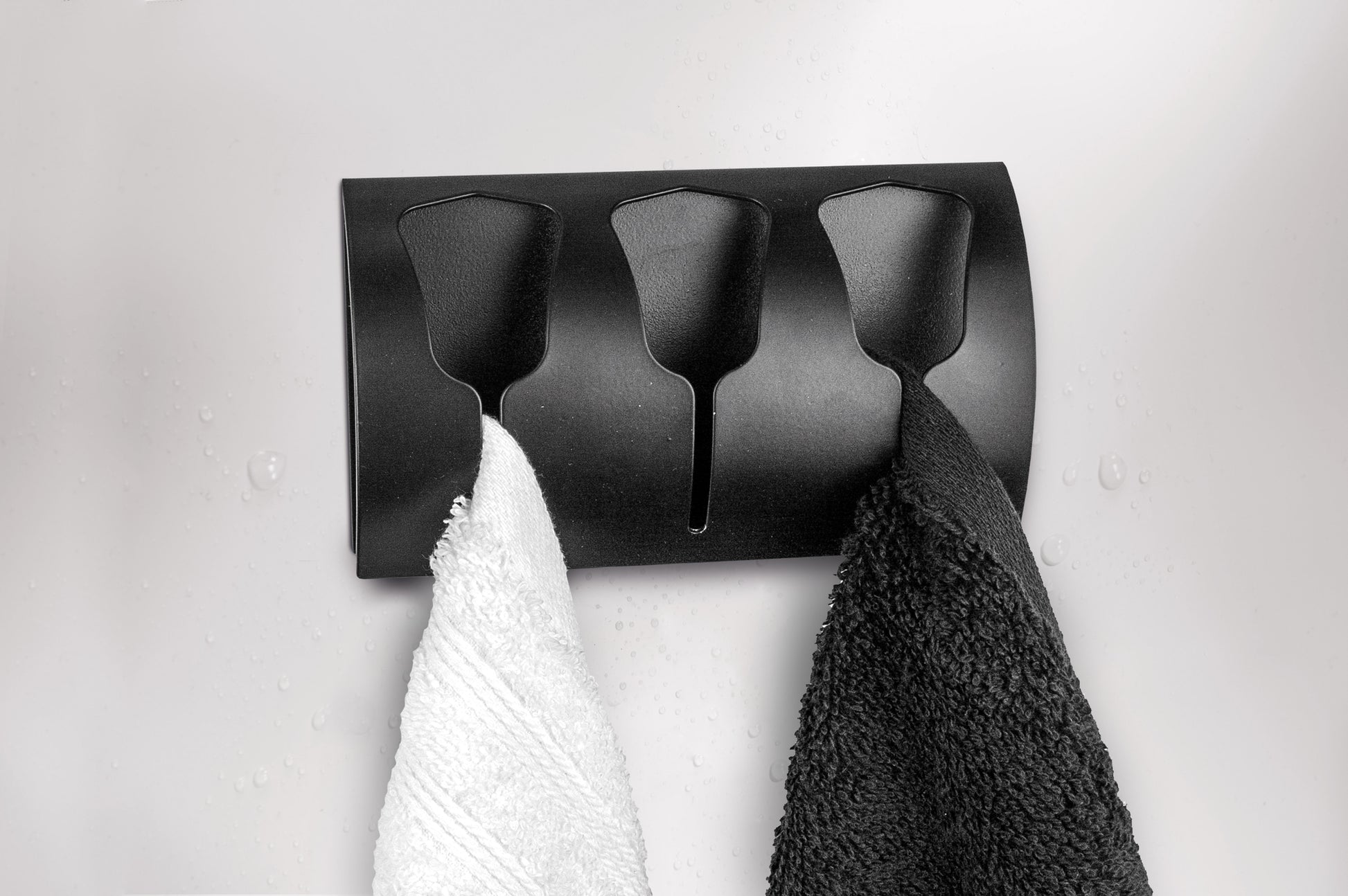 Schwarzer Wandhandtuchhalter mit zwei Handtüchern in Weiß und Schwarz