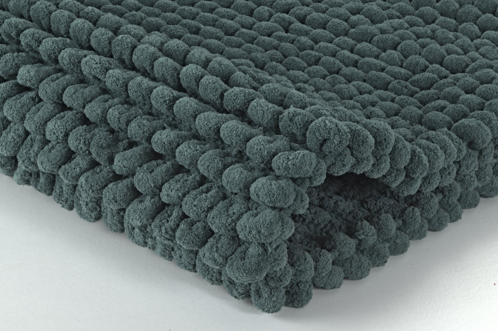 Gefaltete dunkelgrüne Badematte mit dicker, genoppter Struktur Oberfläche