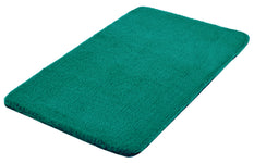 Rechteckige, flauschige, türkisgrüne Badematte auf weißem Hintergrund