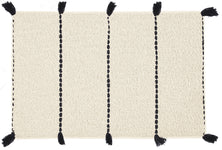 Cremefarbener Badematte mit vier schwarzen Streifen und seitlichen Quasten