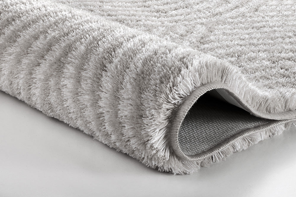 Badteppich CALMA Nebel 70 x 120 cm in Nahaufnahme mit weicher, grauer Hochflorstruktur.