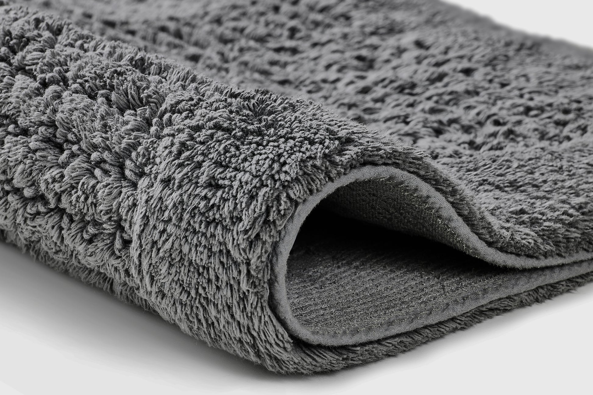 Badteppich NET Schiefer 60 x 60 cm liegt gefaltet und zeigt seine weiche, strukturierte Oberfläche.