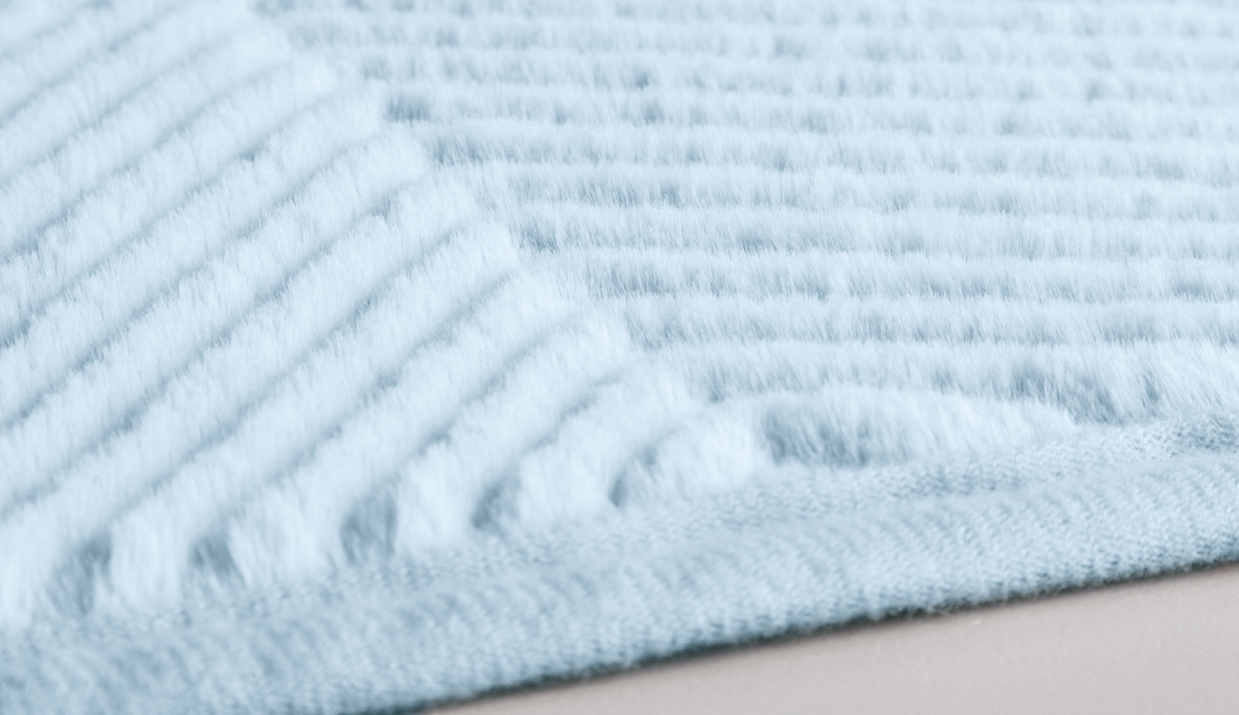 Nahaufnahme einer hellblauen, gerippten Badvorleger-Oberfläche