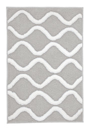 Der Badteppich PIANA Auster 70 x 120 cm liegt mit weißem Wellenmuster auf grauem Grund.