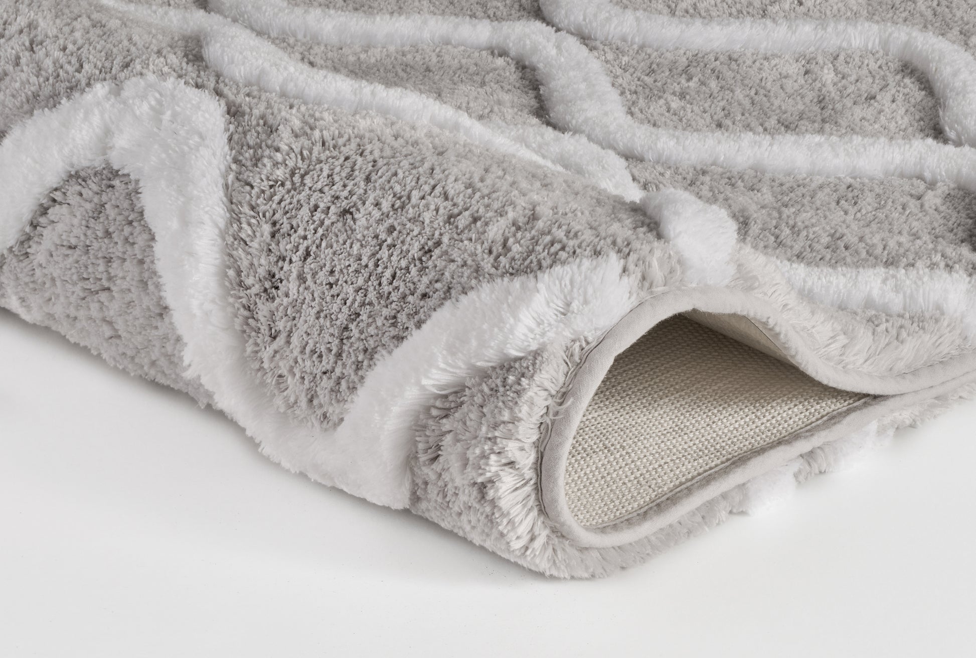 Bild zeigt den Badteppich PIANA Auster 70 x 120 cm in Nahaufnahme mit weißem Linienmuster am Rand.