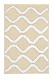 Badteppich PIANA Sandbeige 70 x 120 cm mit weißen Wellen liegt flach auf hellem Hintergrund.