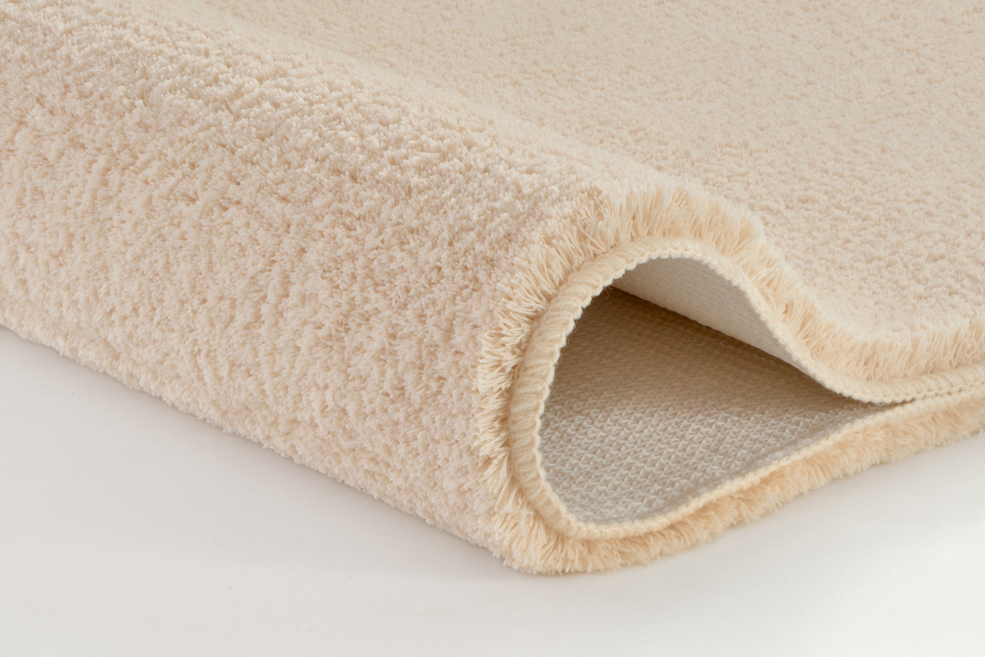 Badteppich MARCO Sandbeige 70 x 120 cm als weicher, gerollter Teppich in Nahaufnahme dargestellt.