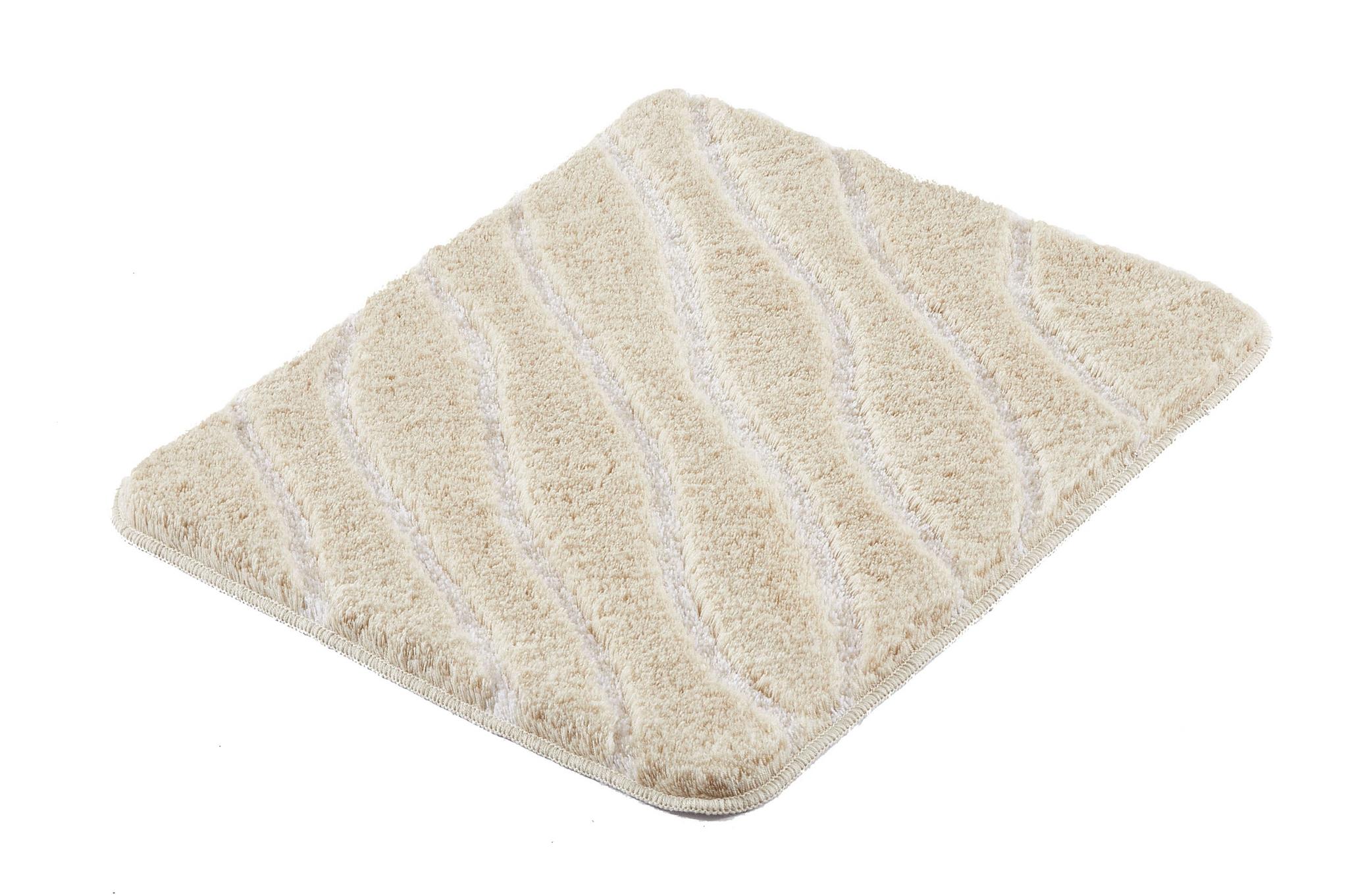 Rechteckige beige Badematte mit Wellenmuster auf weißem Hintergrund