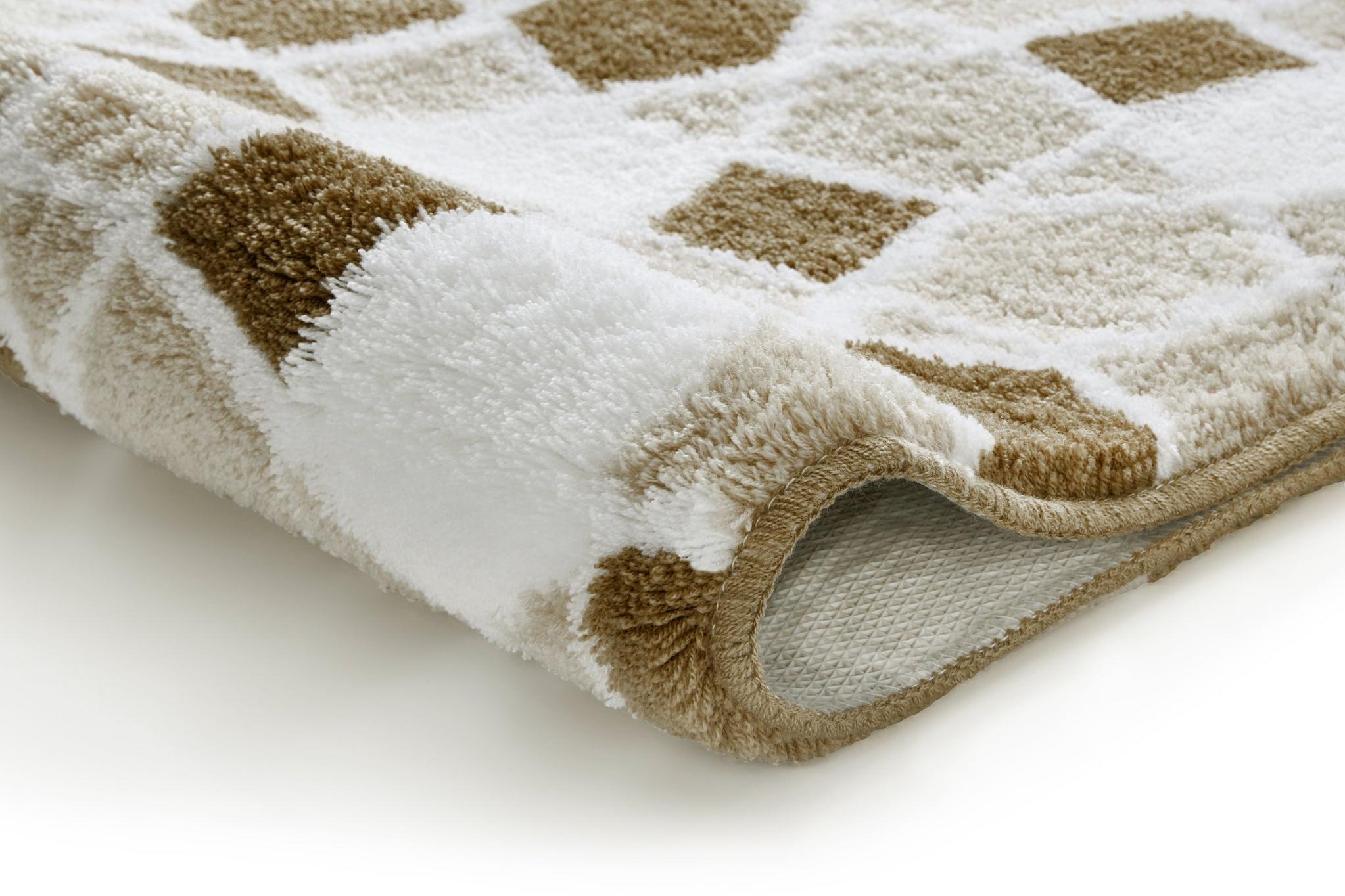Nahaufnahme einer weichen Badematte mit beige-braunem Karomuster aus Stoff
