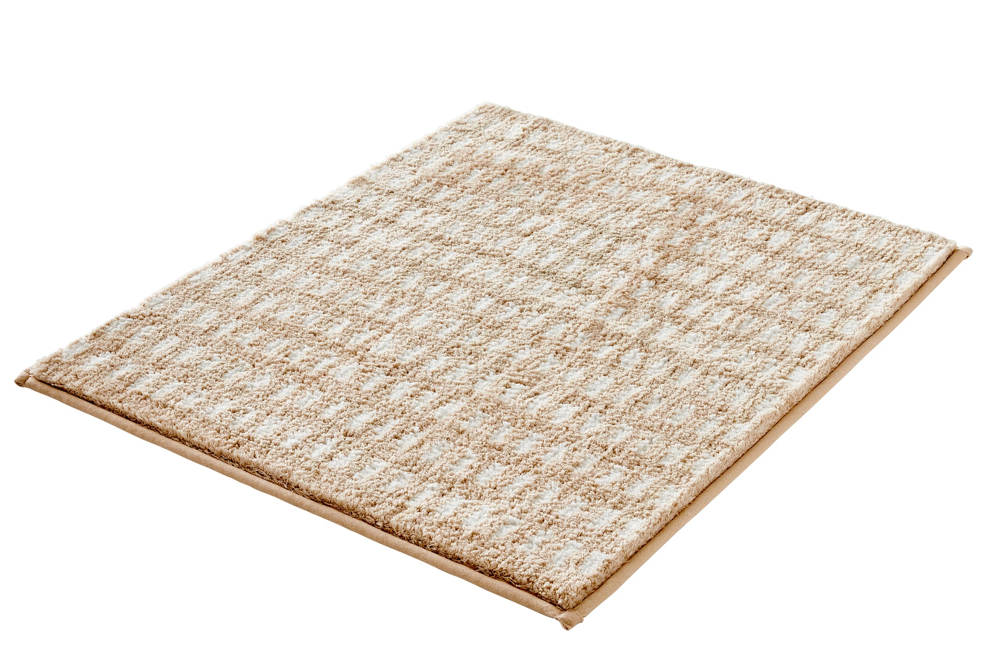 Rechteckiger Badteppich DOTTINO Macadamia 55 x 65 cm in Beige liegt auf weißem Hintergrund.