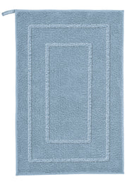 Badteppich NICO in Stahlblau 50 x 80 cm liegt rechteckig mit Bordüre flach auf dem Boden.