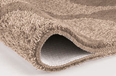 Nahaufnahme einer beigen Badematte mit weicher, dichter Schlingenstruktur