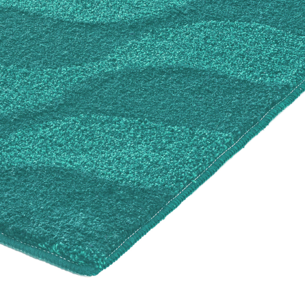 Türkisgrüne Badematte mit Wellenmuster, Detailansicht der Kante unten