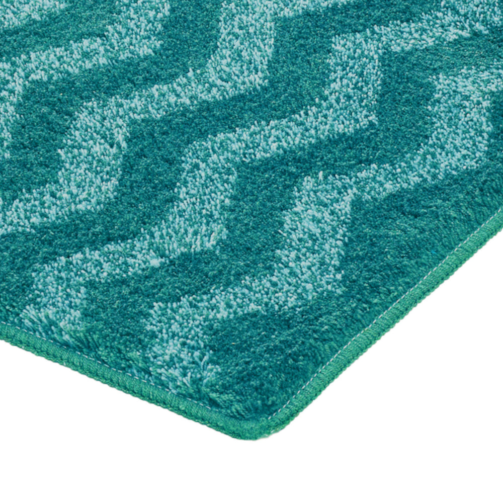 Nahaufnahme eines türkisfarbenen Badteppichs mit Wellenmuster
