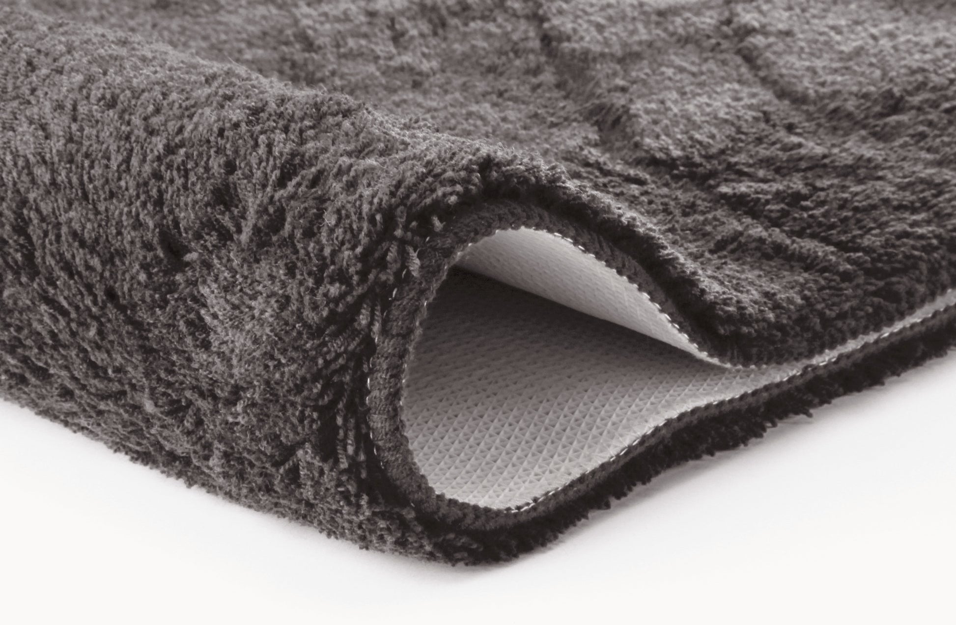 Nahaufnahme dunkelgraue Badematte mit weicher Oberfläche und Unterseite