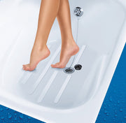 Füße stehen in Dusche auf aufgeklebten Anti-Rutsch-Stickern TAPE Clear 5 Meter am Wannenboden.