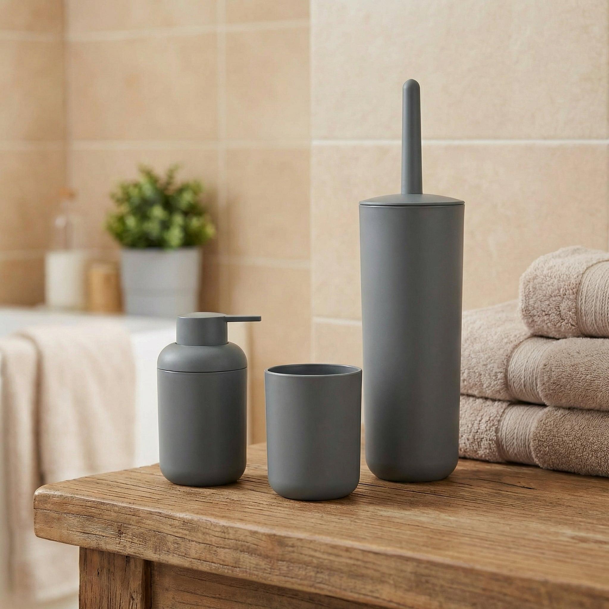 Graues Badaccessoire-Set mit Seifenspender, Becher und WC-Bürste auf Holz
