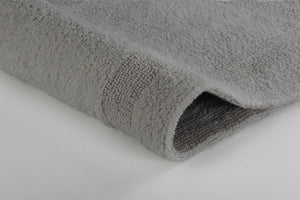Nahaufnahme einer grauen, flauschigen Badematte mit deutlichem Texturdetail