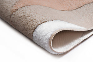 Nahaufnahme eines beige-weißen Badematte-Rands mit weicher Struktur