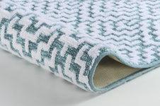 Weiche Badematte in Nahaufnahme mit weiß-türkisfarbenem Zickzackmuster