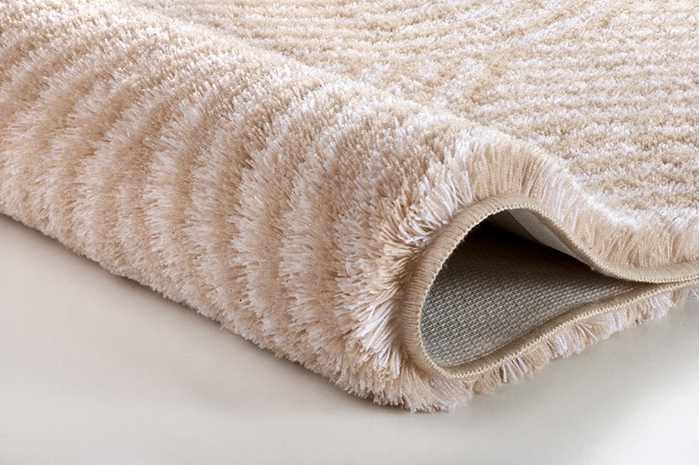 Beiger, flauschiger Badteppich in Nahaufnahme mit strukturierter Oberfläche