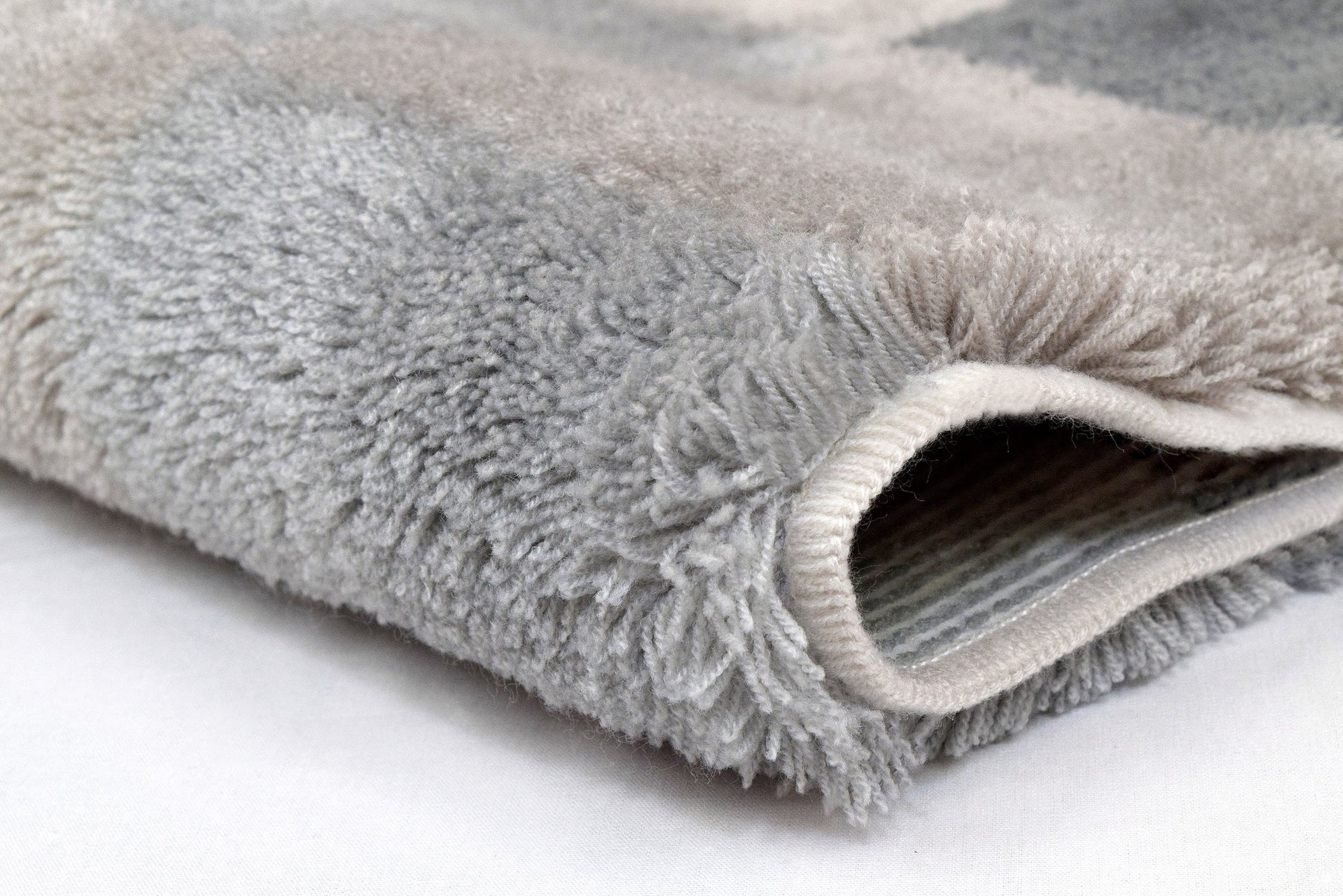 Nahaufnahme des grauen Badteppichs CARO Flanell 60 x 105 cm mit weichem Flor.