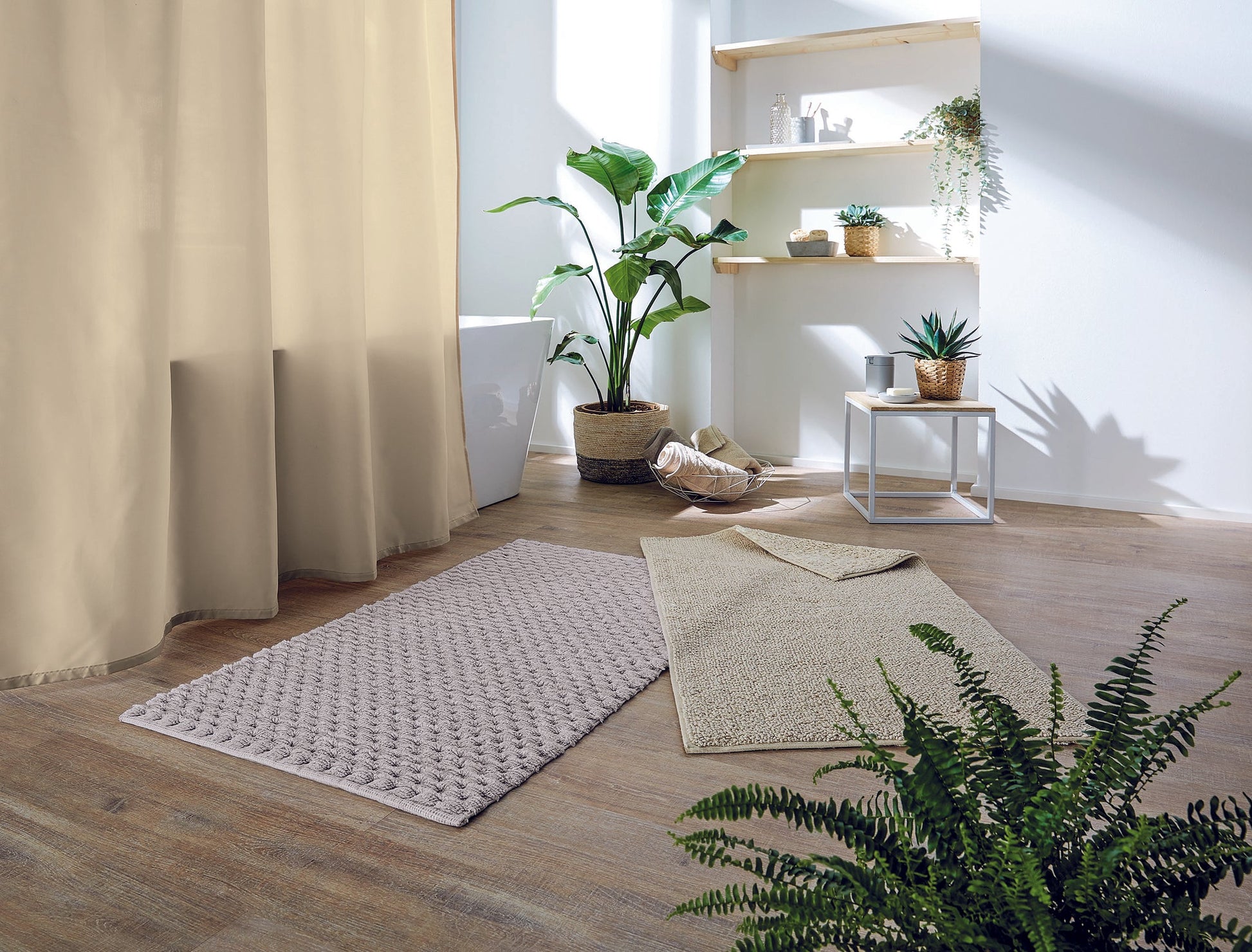Badteppich CHRISSY Natur 60 x 100 cm liegt in heller Badumgebung mit Pflanzen auf Holzboden.