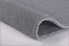 Graue, flauschige Badematte aus dichtem Frottier in Detailansicht nah