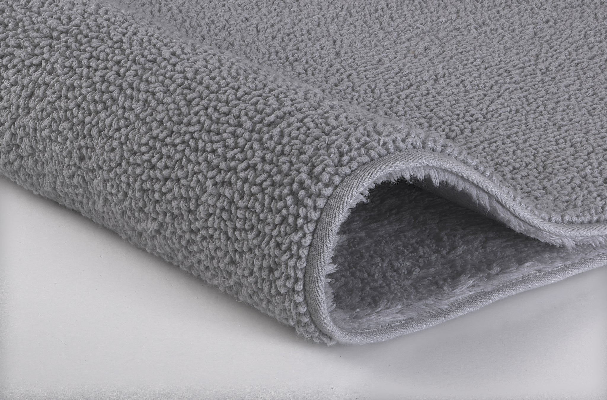 Das Bild zeigt eine Nahaufnahme des Badteppichs CHRISSY in Silbergrau, 65 x 115 cm.