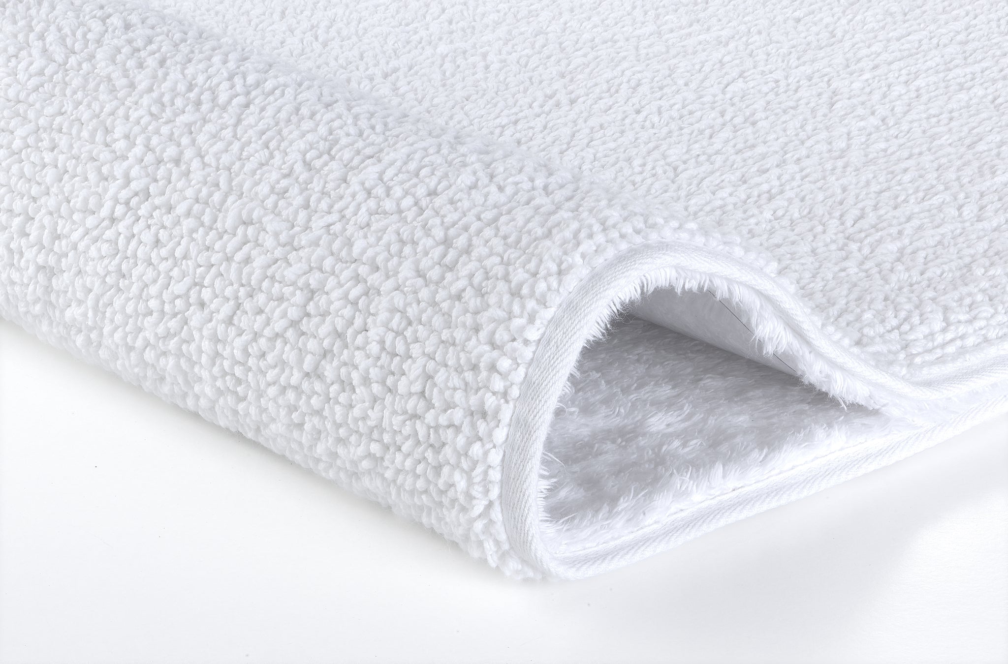 Nahaufnahme des weißen Badteppichs CHRISSY 60 x 100 cm mit weicher, strukturierter Oberfläche.