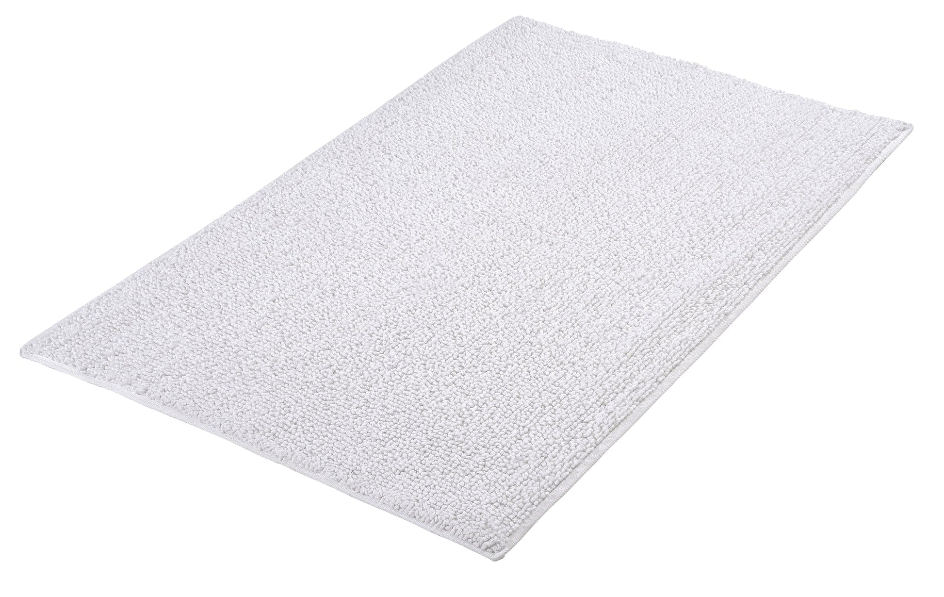 Badteppich CHRISSY in Weiß mit Größe 60 x 100 cm liegt auf dem Boden.