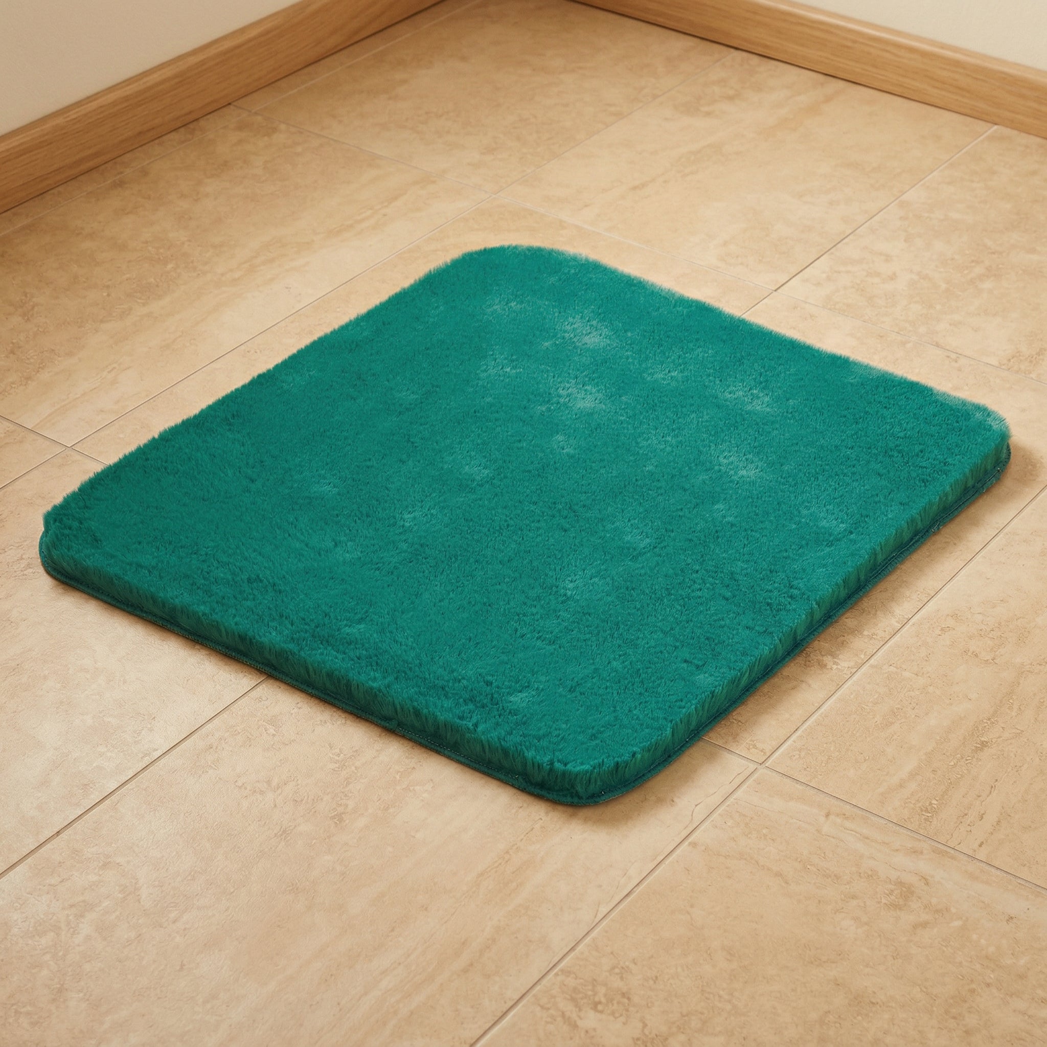 Quadratische türkisfarbene Badematte auf hellen Badezimmerfliesen