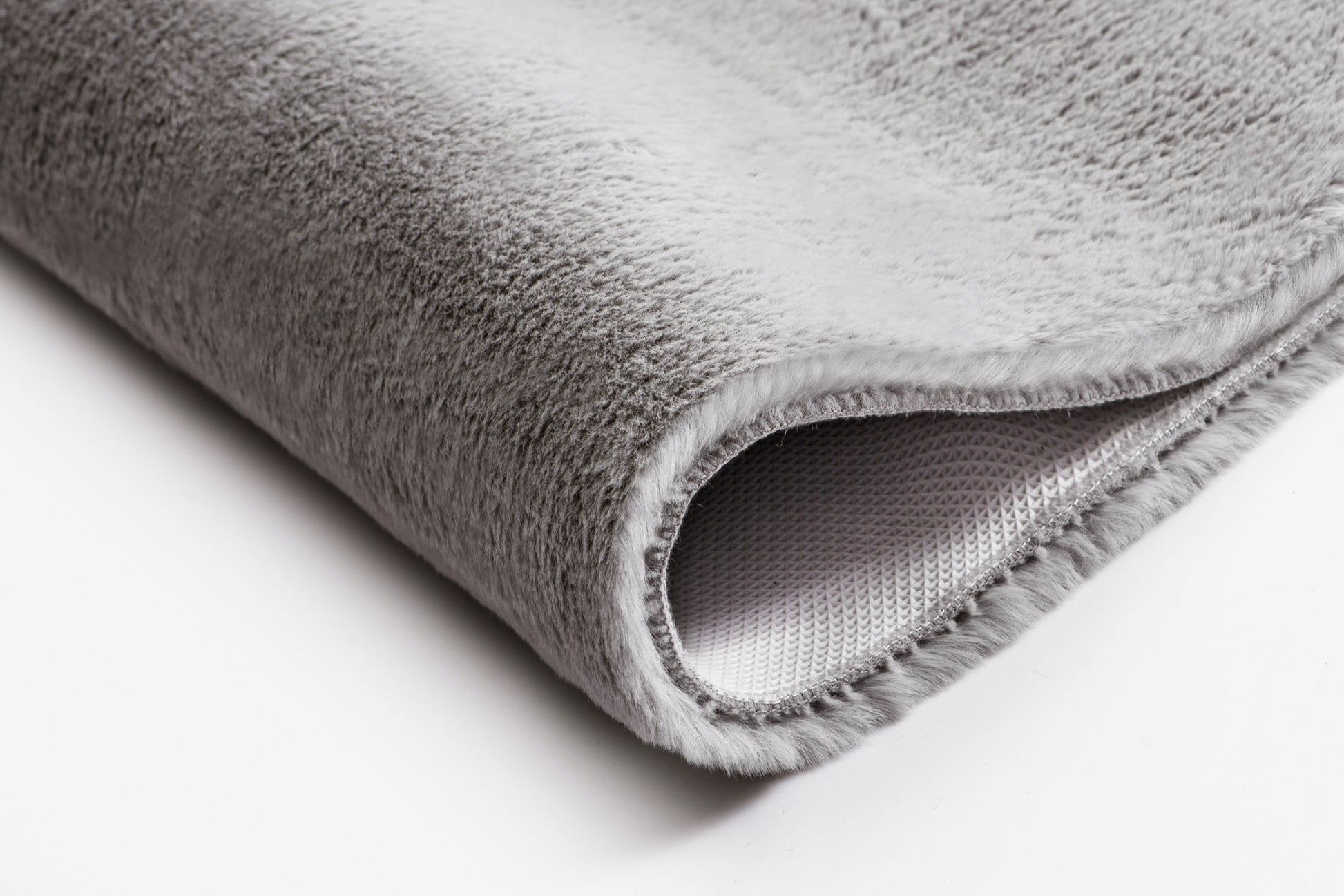 Graue, weiche, flauschige Badematte mit rutschfester Unterseite, unten