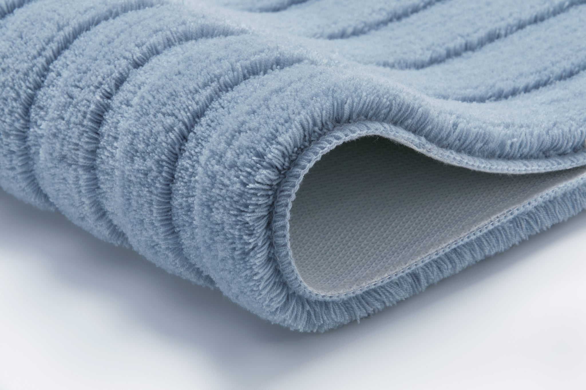 Hellblaue, gerippte Badematte in Nahaufnahme mit extraweichem Flor