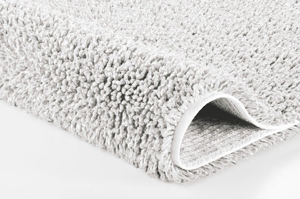 Badteppich DANA Polarweiß 60 x 60 cm liegt als Nahaufnahme mit sichtbarer Kante auf hellem Untergrund.