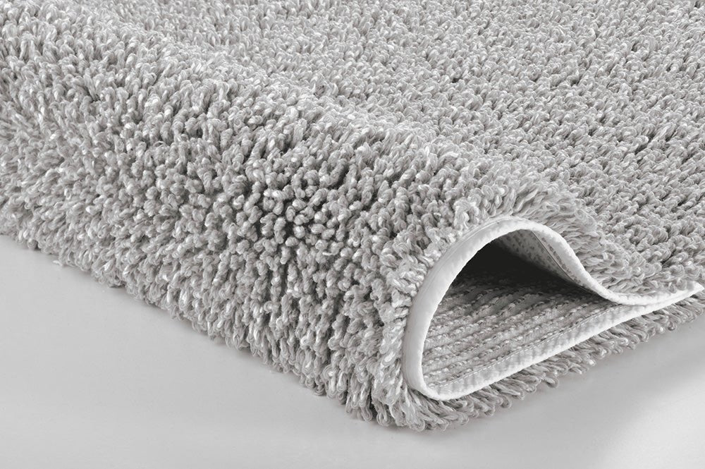 Detailansicht des Badteppichs DANA seidenfarben 60 x 100 cm mit umgeschlagener Ecke.