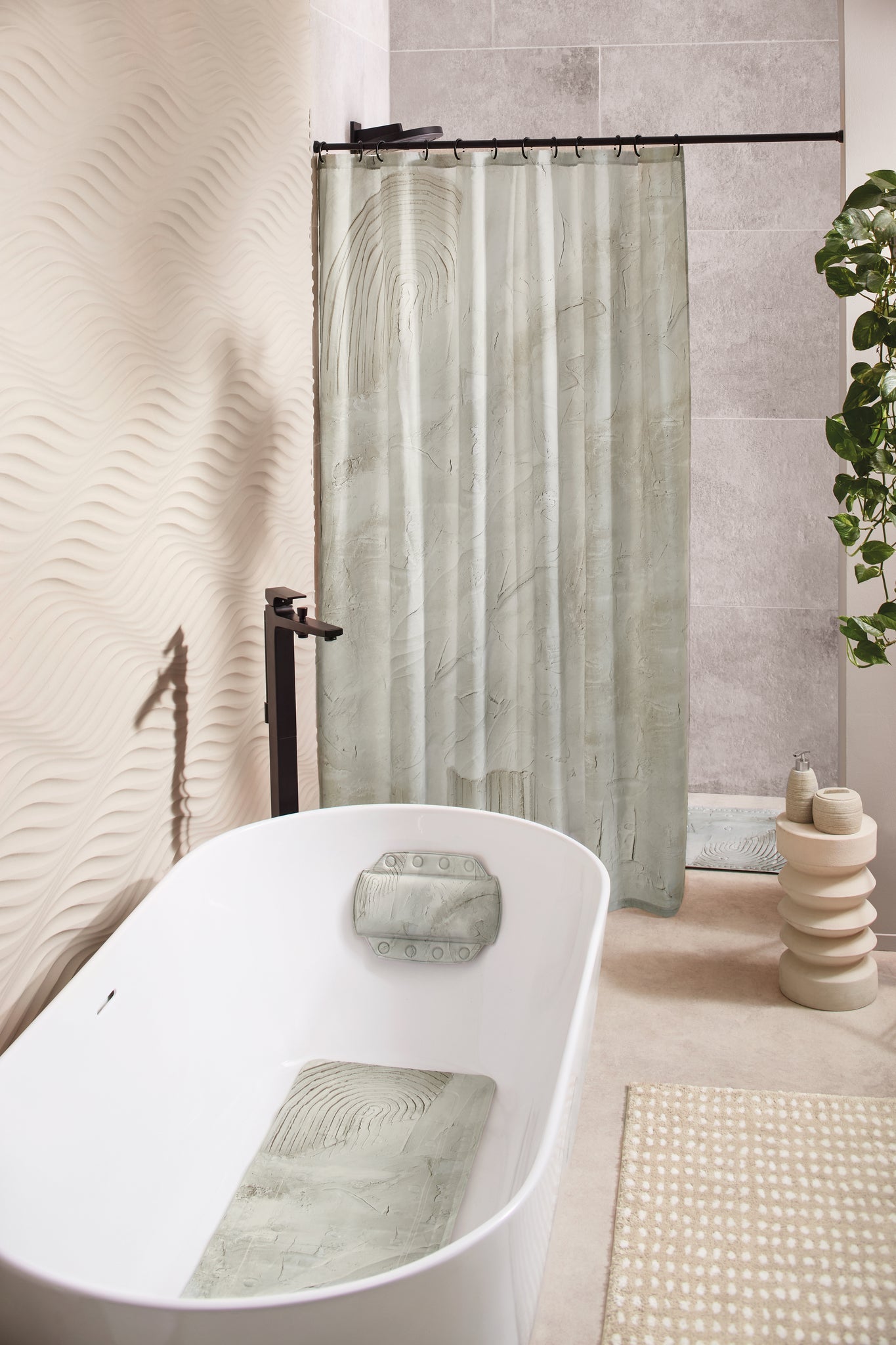 Badteppich DOTTINO Macadamia 55 x 65 cm liegt in modernem Bad neben freistehender Badewanne.