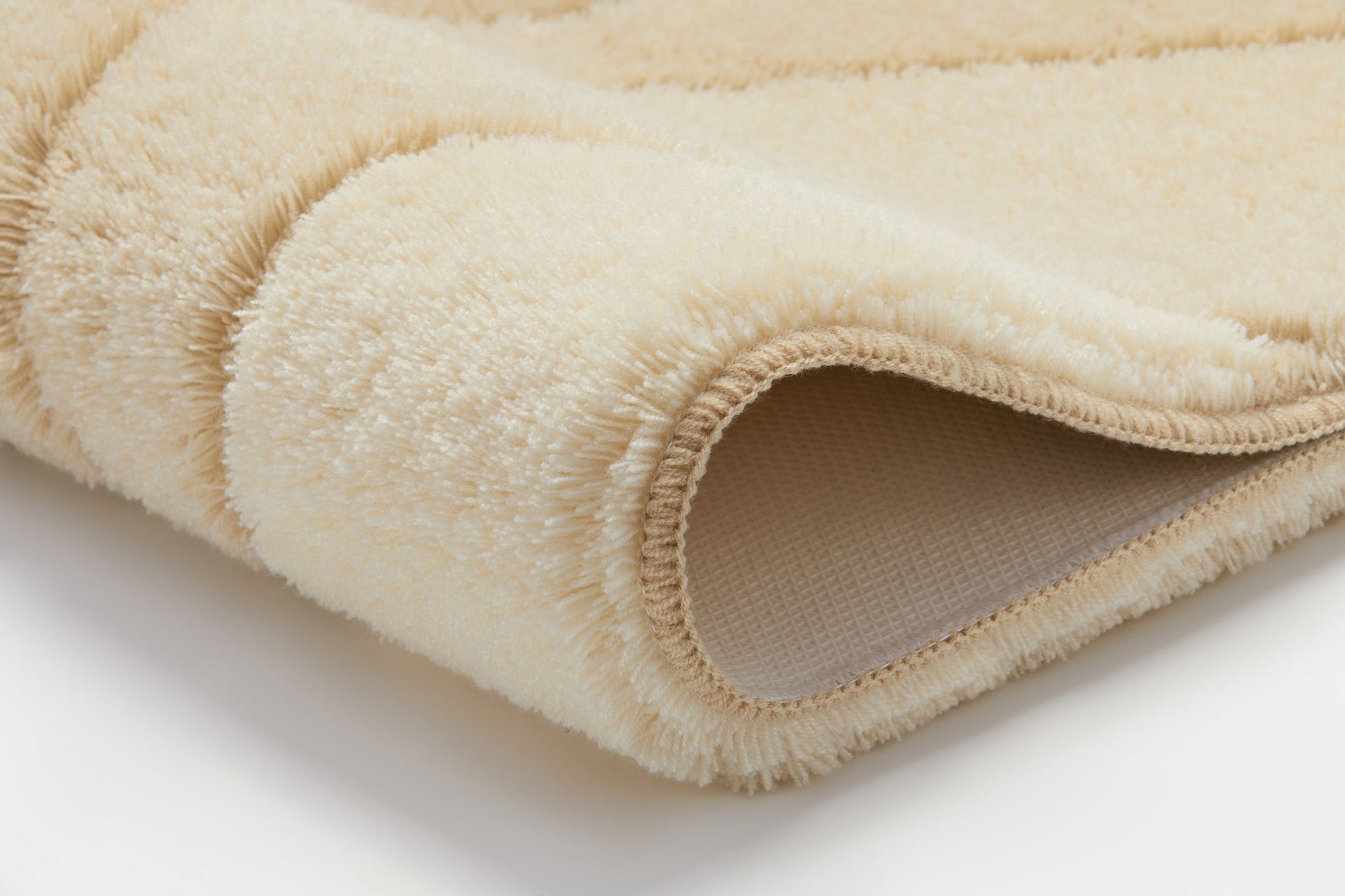 Badteppich FIONA Bahamabeige 70 x 120 cm liegt weich gefaltet und zeigt seine flauschige Struktur.